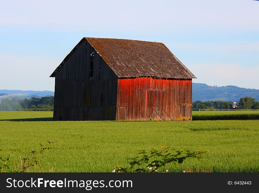 An old red barn shines in the morning sun. An old red barn shines in the morning sun.