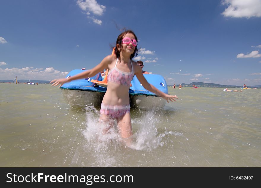 Young girl splashing into the water from paddleboat