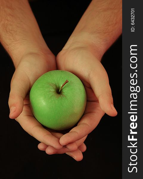 Hands holding fresh, green apple