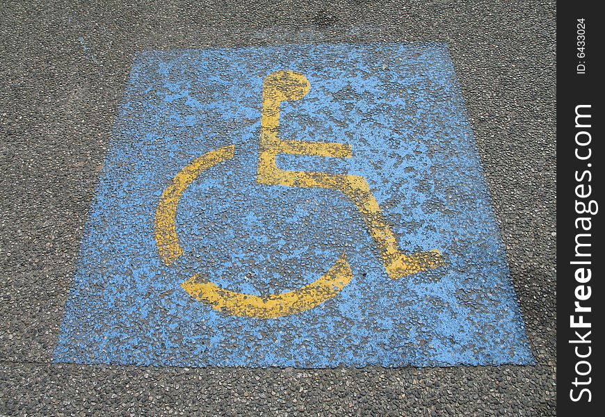 Blue and yellow painted wheelchair parking sign