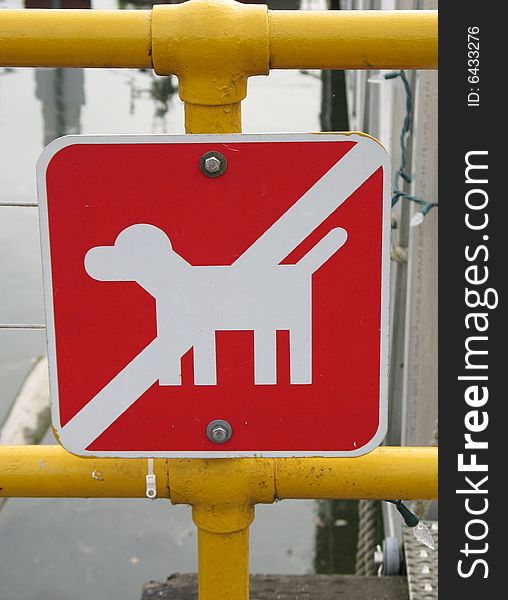 Red no dog sign on a yellow fence