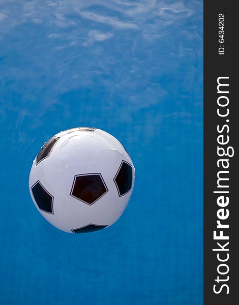 Inflatable plastic ball floating on a calm swimming pool