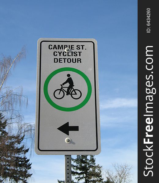 Cyclist detour sign against a blue sky