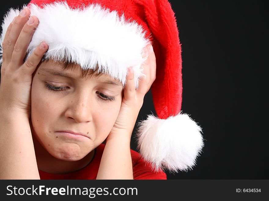 Young boy wearing a red shirt and christmas hat. Young boy wearing a red shirt and christmas hat