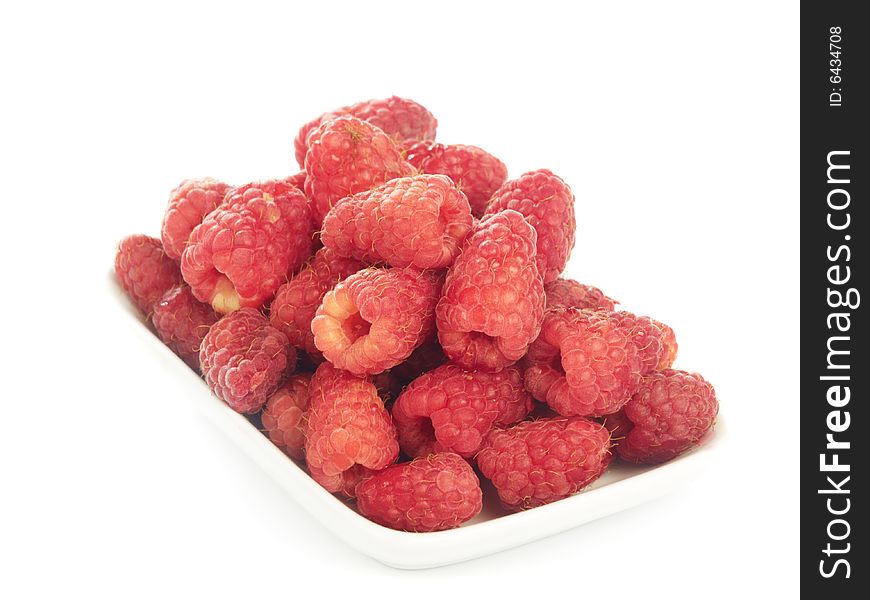 Several ripe raspberries in small plate isolated on white