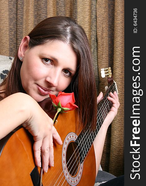 Mature brunette model with a rose and guitar. Mature brunette model with a rose and guitar