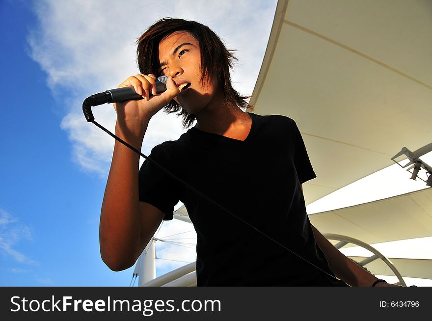 Picture of a young generation rock star with a microphone. Suitable for musical related contexts. Picture of a young generation rock star with a microphone. Suitable for musical related contexts.