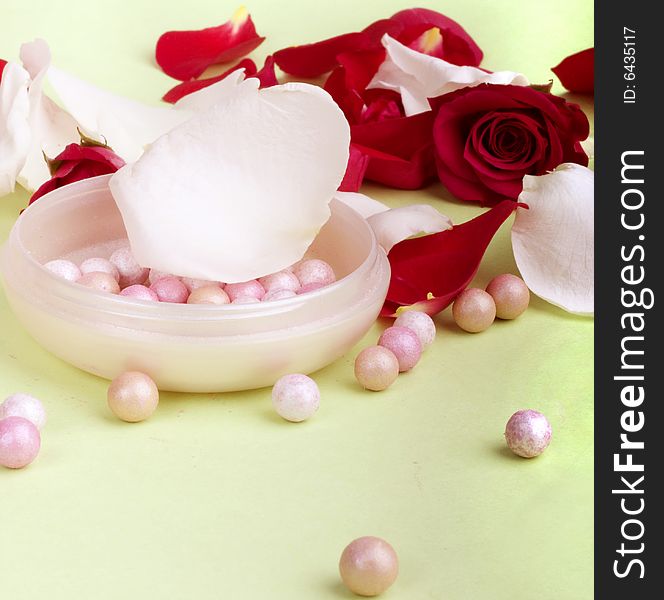 Red and white rose petals and heads with pouder isolated on light background. Red and white rose petals and heads with pouder isolated on light background