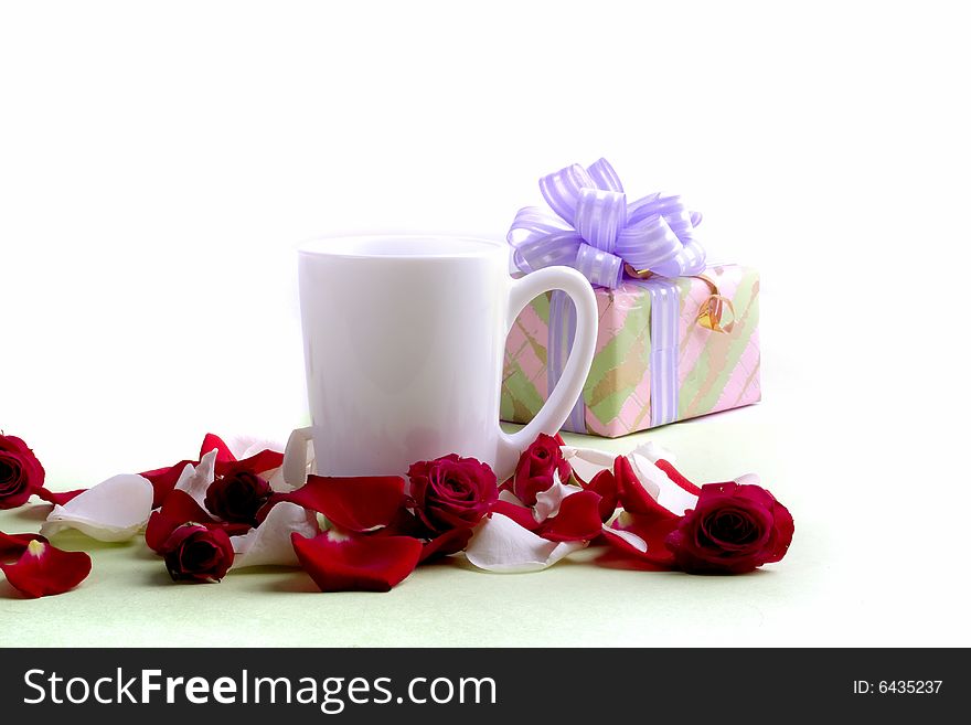 White cup and rose petals and heads with present isolated on white background