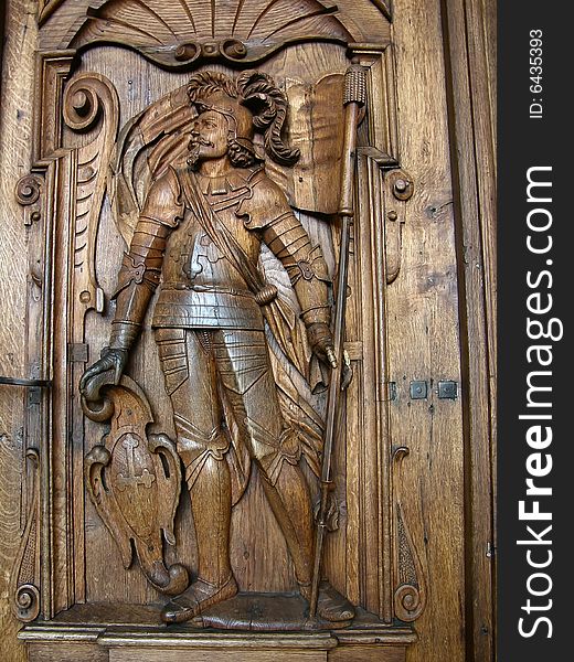 Wooden sculpture of Hofkirche door (Luzern/Lucerne - Switzerland). The church is known as the Church of St. Leodegar. The impressive main doors are carved with the two patron saints of Luzern. On the right is St Maurice, the martyred Roman soldier-saint. Wooden sculpture of Hofkirche door (Luzern/Lucerne - Switzerland). The church is known as the Church of St. Leodegar. The impressive main doors are carved with the two patron saints of Luzern. On the right is St Maurice, the martyred Roman soldier-saint.