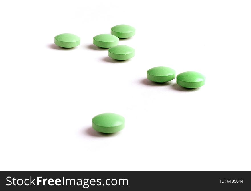 Green pills close-up isolated on white background. Green pills close-up isolated on white background