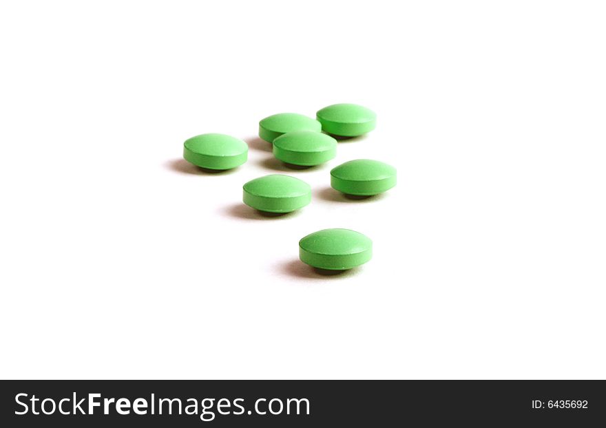 Green pills close-up isolated on white background