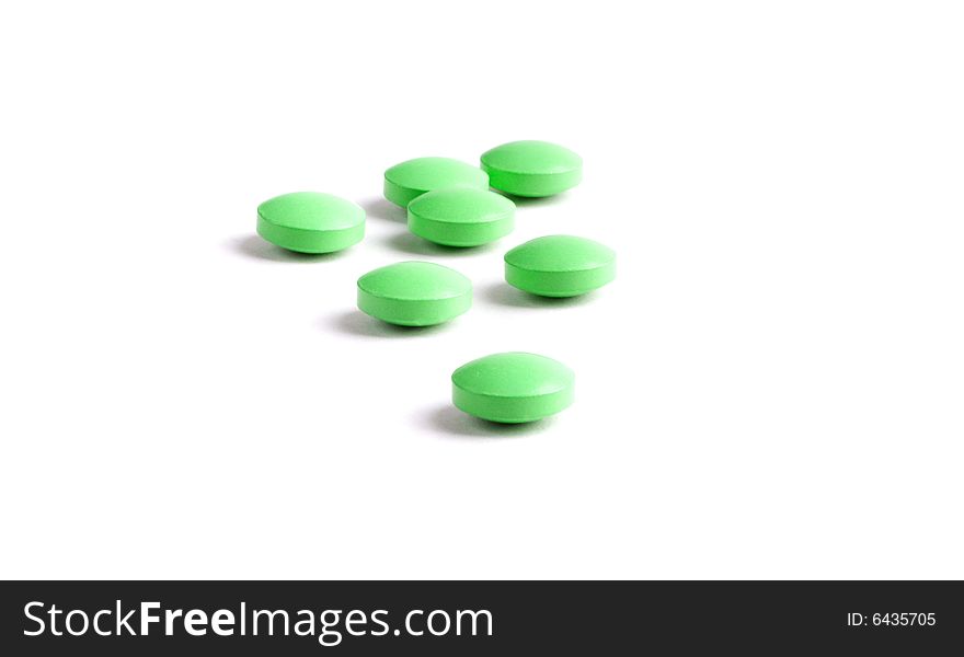 Green pills close-up isolated on white background