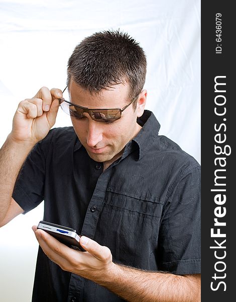 Young man in sunglasses looking at his cellphone
