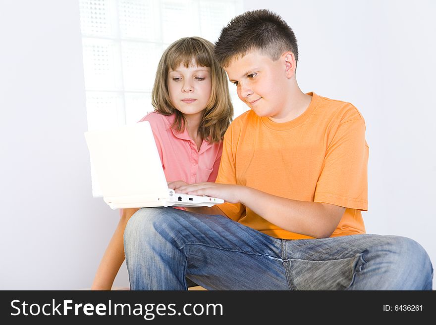 Young boy showing to girl something in laptop. Young boy showing to girl something in laptop.
