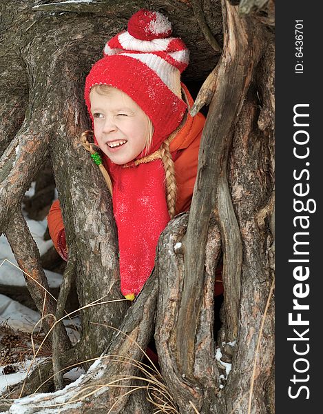 The girl costs between roots of a tree and has blinked one eye. The girl costs between roots of a tree and has blinked one eye