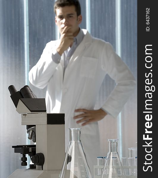 Scientist thinking in his lab near the microscope. Scientist thinking in his lab near the microscope