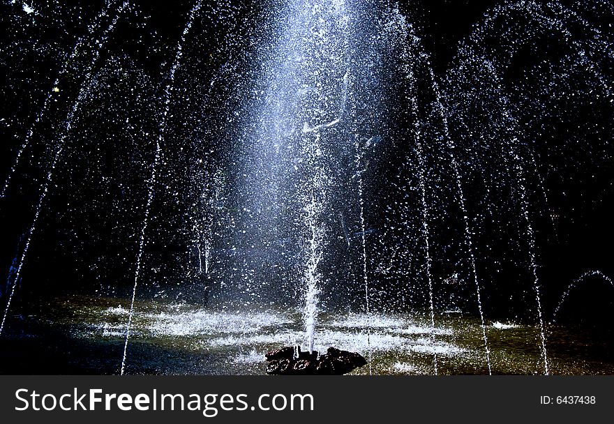 Fountain and water streams on a dark background