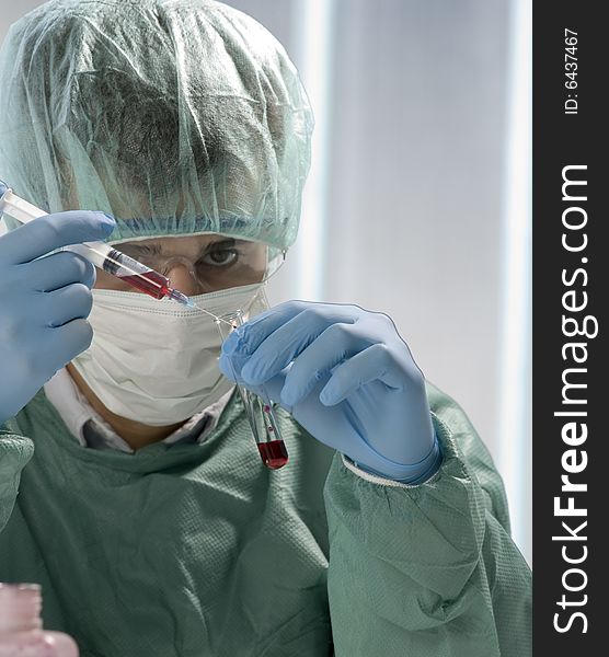 Scientist working in his laboratory with flask and syringe. Scientist working in his laboratory with flask and syringe