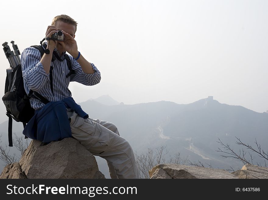 Man taking pictures or video atop the Great Wall of China