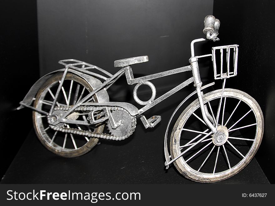 Miniature replica authenticates old bicycle with front basket. Miniature replica authenticates old bicycle with front basket