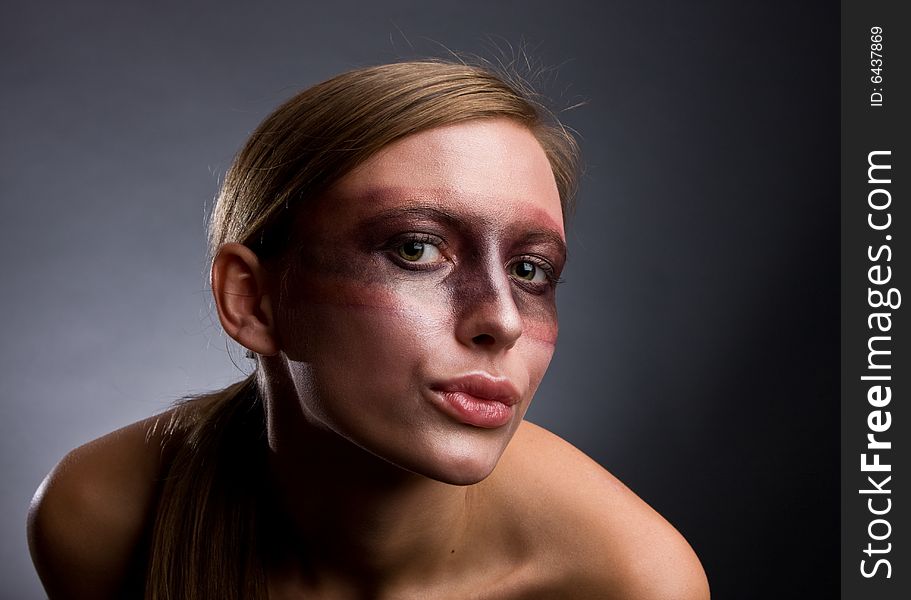 Studio portrait of a young blond woman with aggressive make-up