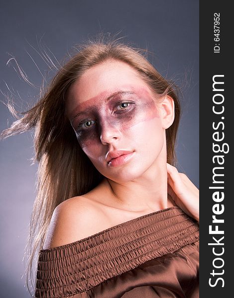 Studio portrait of a young blond woman with aggressive make-up