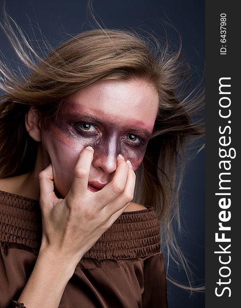 Studio portrait of a young blond woman with aggressive make-up