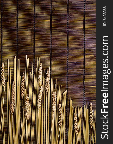Brown bamboo board background with italian pasta and grain. Brown bamboo board background with italian pasta and grain