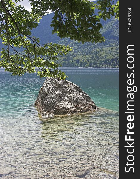 Rock in lake Bohinj (Slovenia) on a sunny summer afternoon.