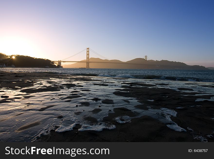 Golden Gate at the dusk with water on sand