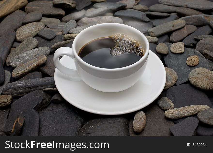 Cup Of Coffee Against Black Stones