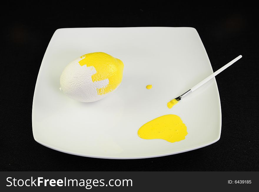 Lemon being painted on a white plate. Lemon being painted on a white plate.