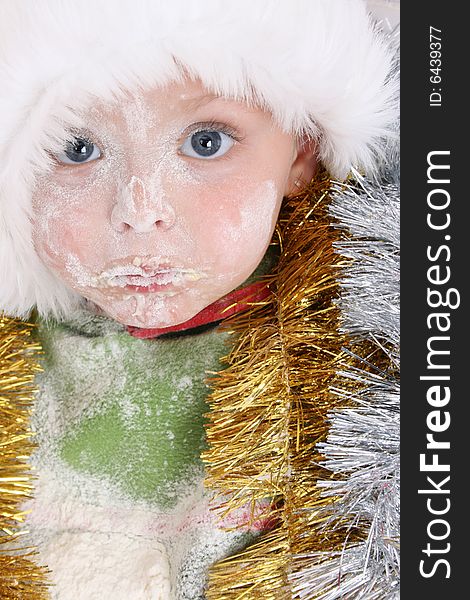 Toddler wearing a christmas hat, covered in flour. Toddler wearing a christmas hat, covered in flour