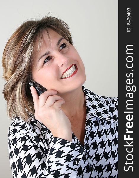 Friendly Business woman talking on a cell phone. Friendly Business woman talking on a cell phone
