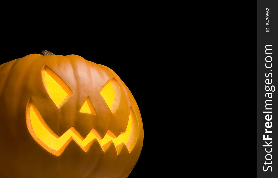 Scary Jack O' Lantern Lit Up on Black Background. Scary Jack O' Lantern Lit Up on Black Background