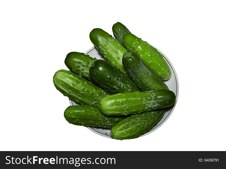 Cucumbers on a plate, it is isolated on a white background. Cucumbers on a plate, it is isolated on a white background