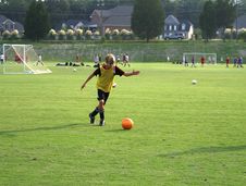 Boy Kicking A Ball On The Field. Stock Photos Boy Kicking A Ball On The Field. Stock Photos