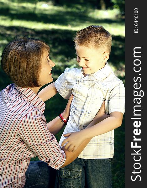 Mother and son looking at each other smiling in the nature. Mother and son looking at each other smiling in the nature