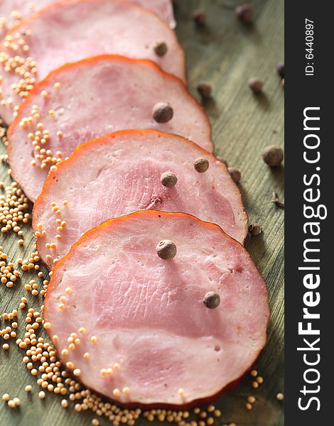 Slices of sausage and spice grains on the chopping board