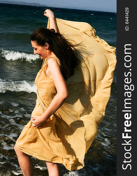 Beautiful young woman dancing by the seaside