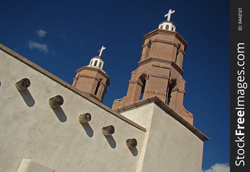 Mission style church made of stucco and stone as viewed from side