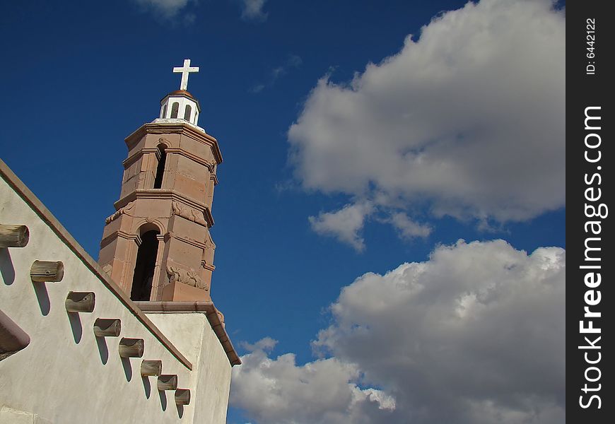 Mission style church with stucco exterior and stone steeple