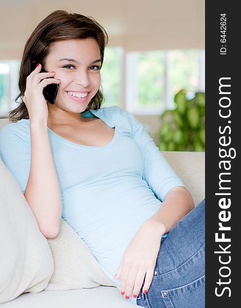 A lifestyle shot of an attractive young woman on the phone. A lifestyle shot of an attractive young woman on the phone