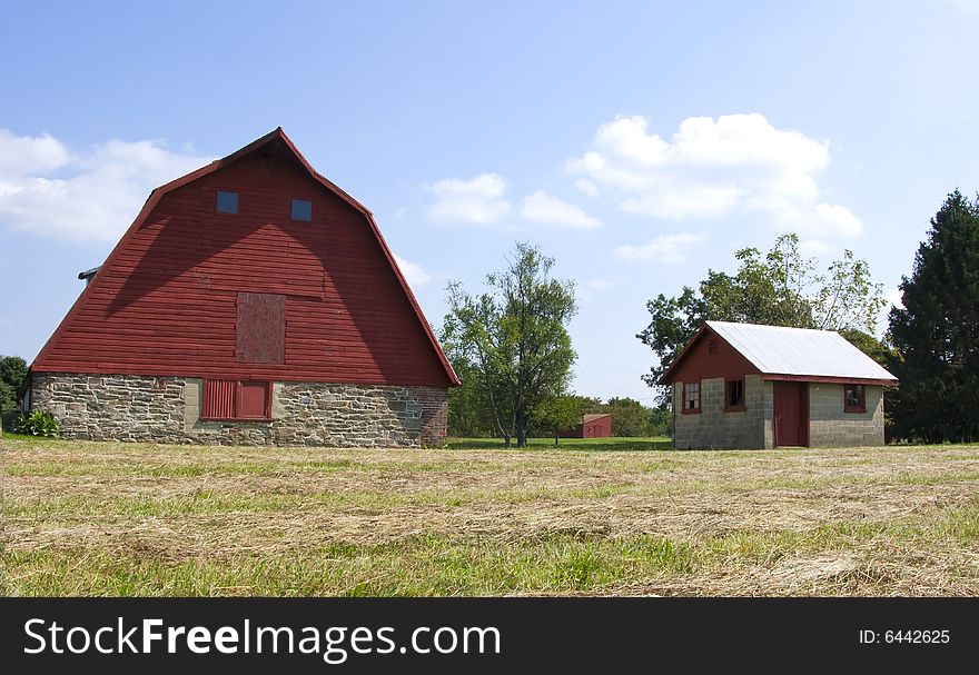 A traditional red barn and small shed