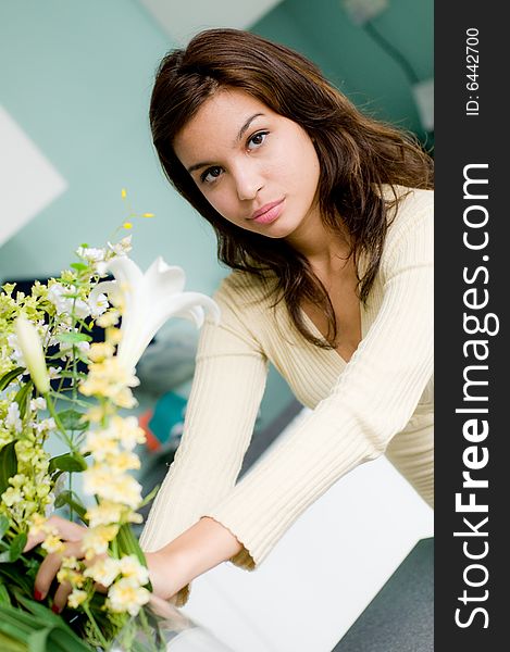 An attractive young woman flower arranging at home