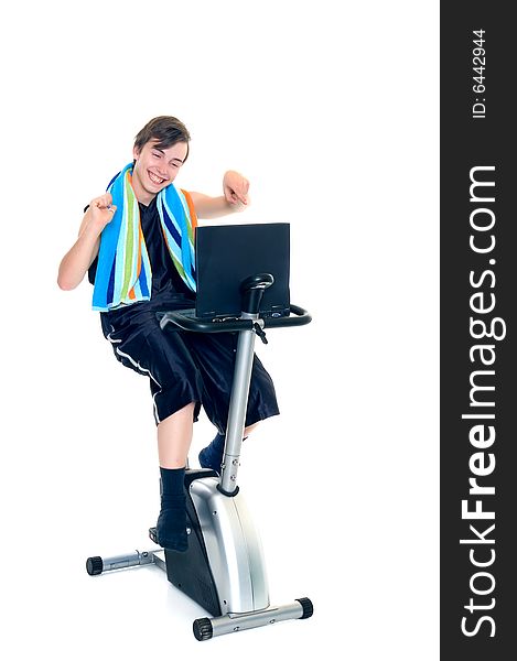 Young teenager boy doing fitness on home-trainer with laptop studying,. Young teenager boy doing fitness on home-trainer with laptop studying,