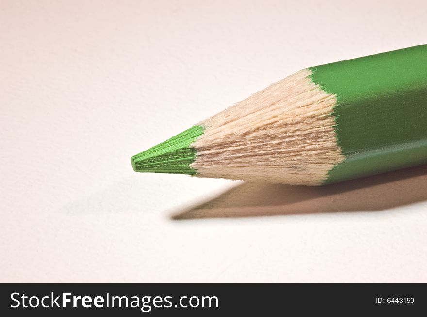 A green pencil lying diagonal on a table. A green pencil lying diagonal on a table.