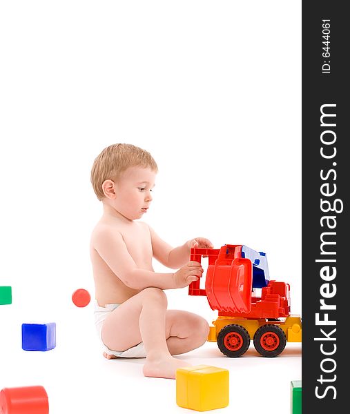 Little boy play with toys over white background with light shadows.