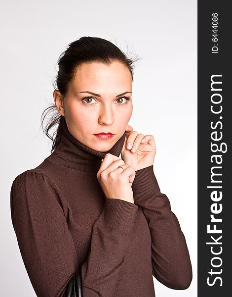 Portrait of the charming girl with dark hair on a light background